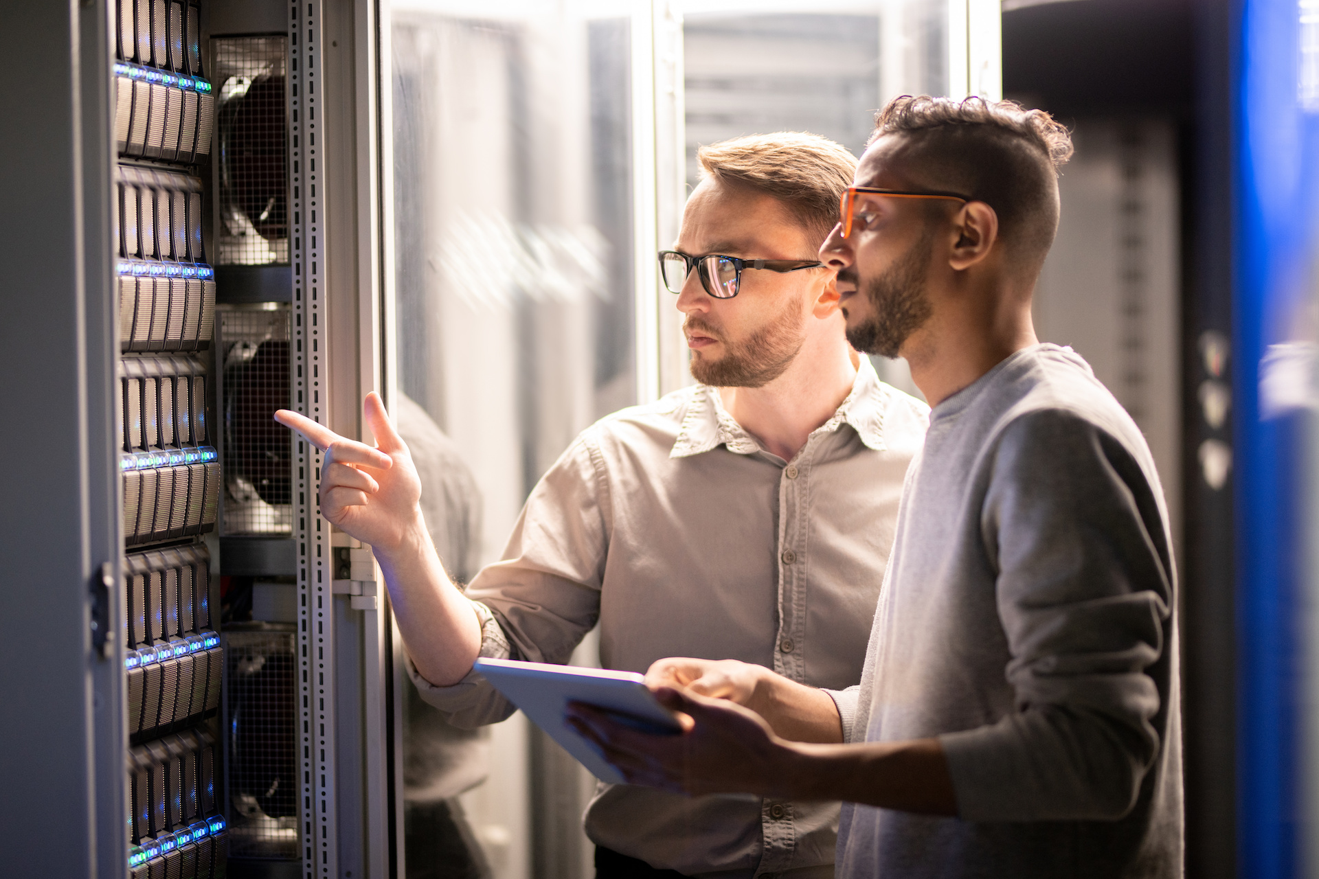 two men looking at servers in a server room