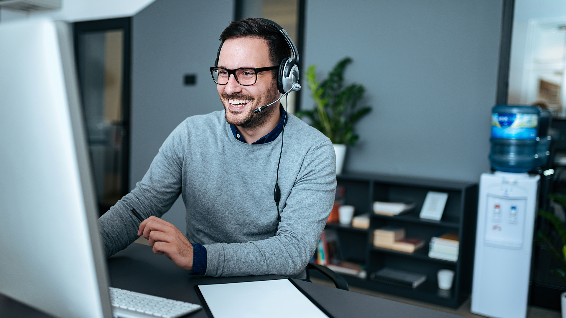 a man wearing headphones sitting in front of a computer
