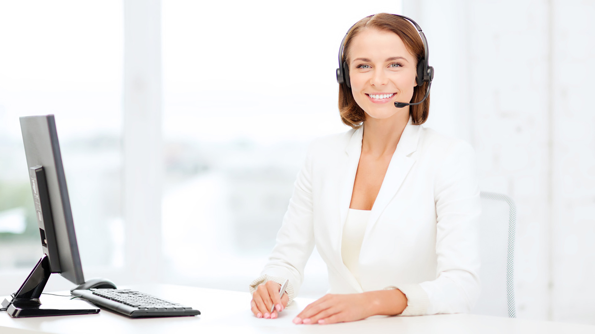 a woman wearing a headset sitting in front of a computer