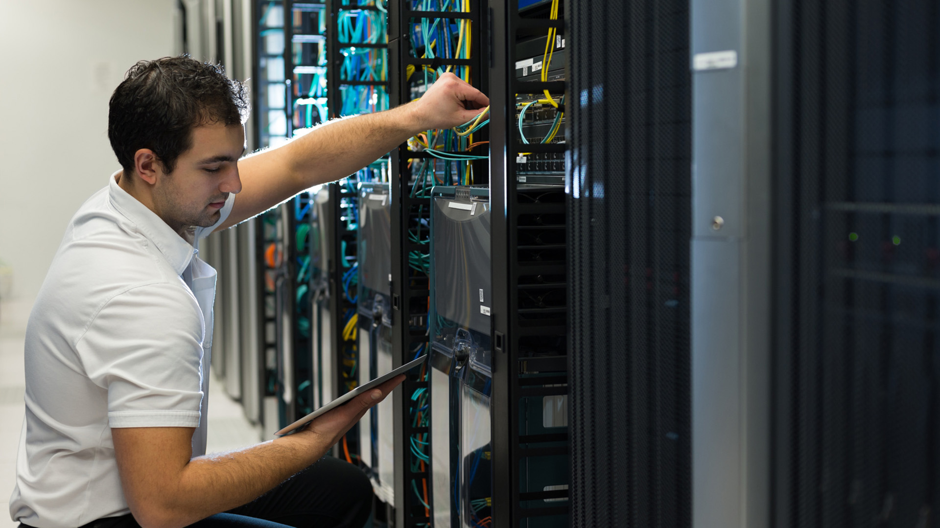 a man in a white shirt is working on a server