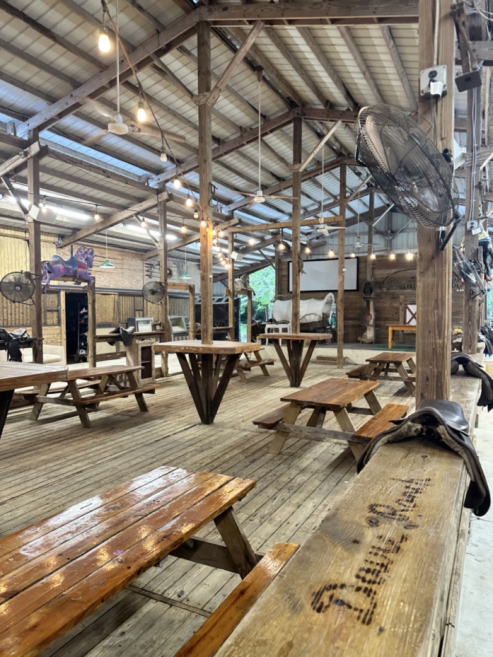 a wooden table and benches inside of a building