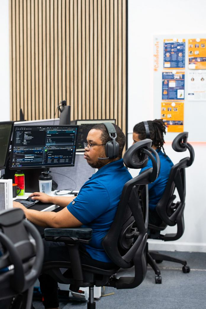 two people sitting at a desk with headphones on