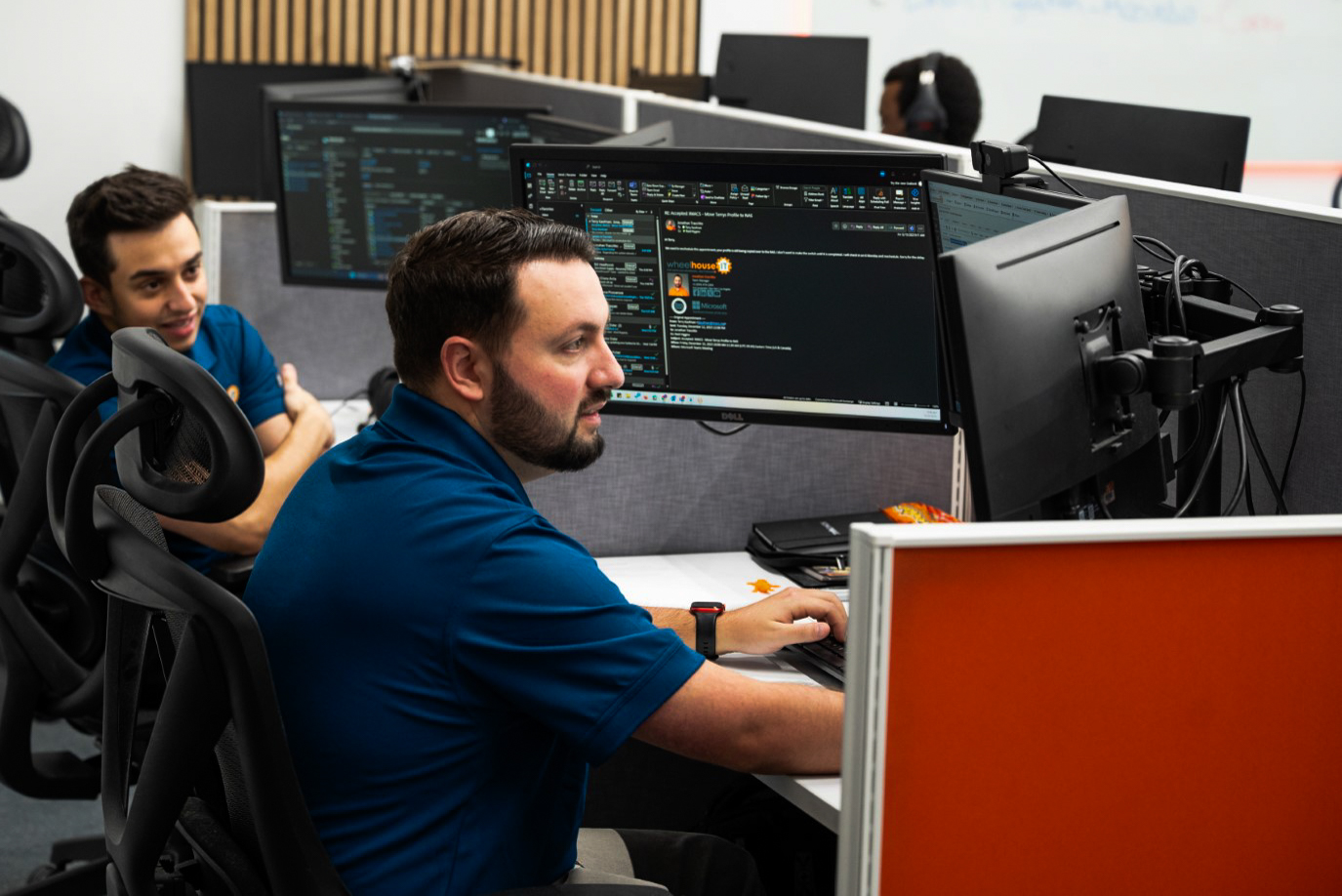 two men working on computers in an office