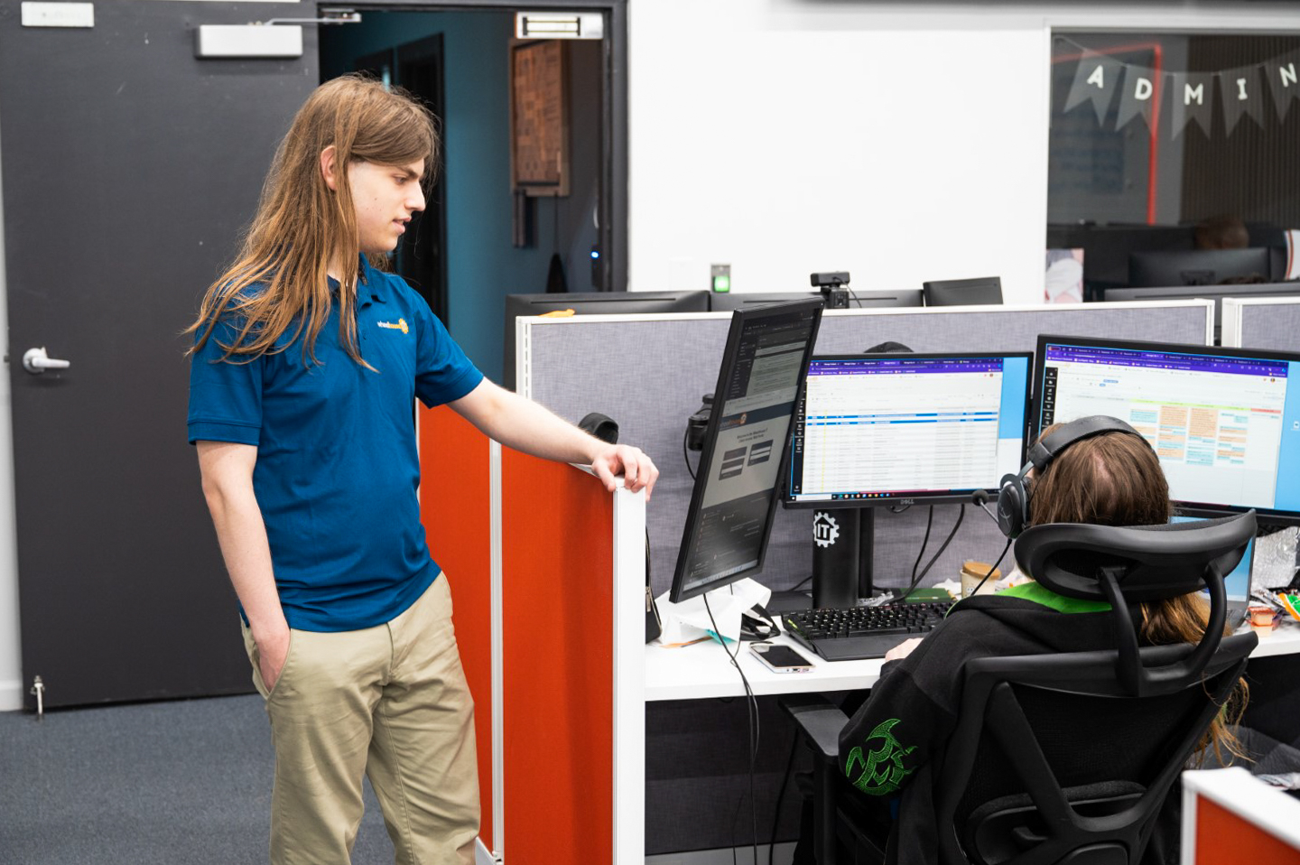 a man standing next to a woman in front of a computer