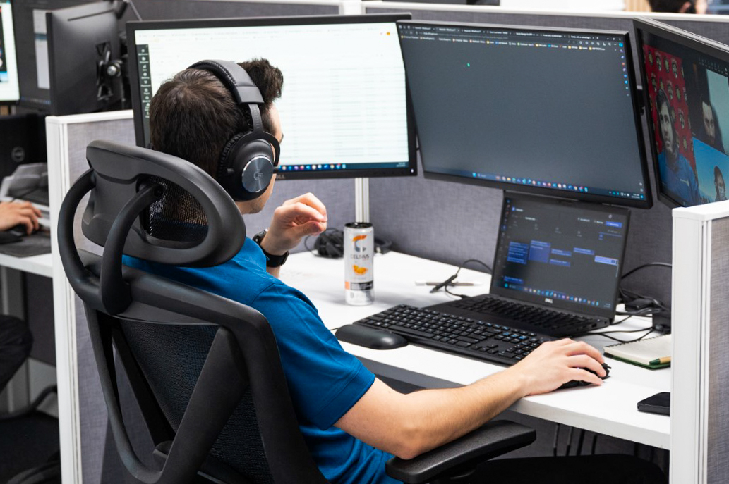 a man sitting at a desk with headphones on