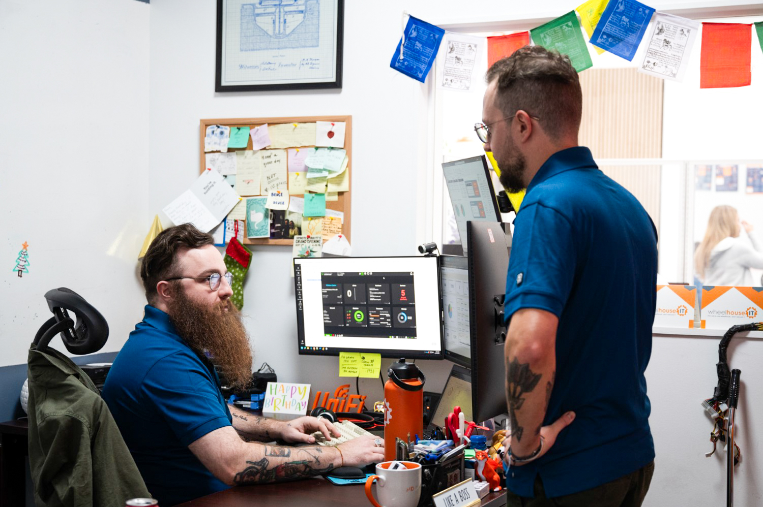 two men sitting at a desk in an office