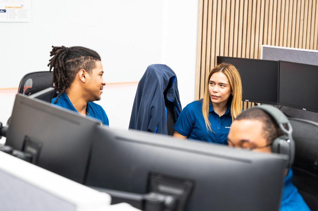 two people sitting in front of computer monitors