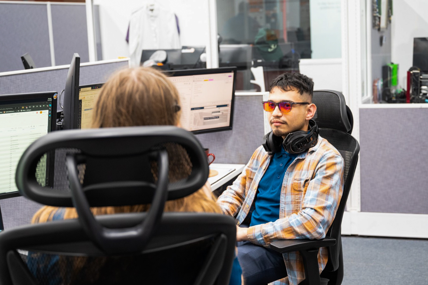 a man sitting in front of a computer monitor wearing headphones