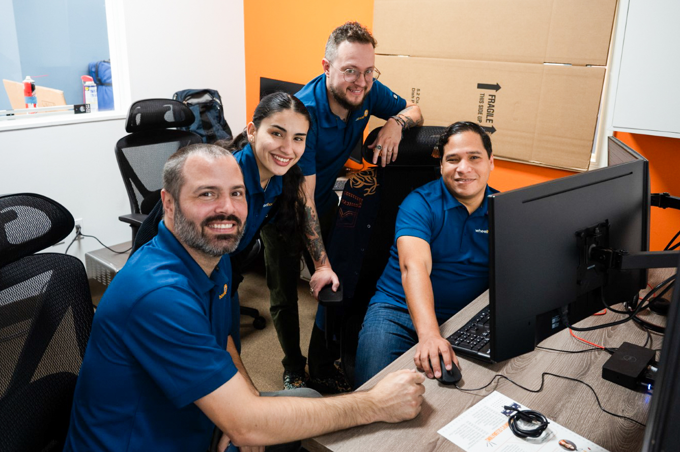 a group of people standing around a computer