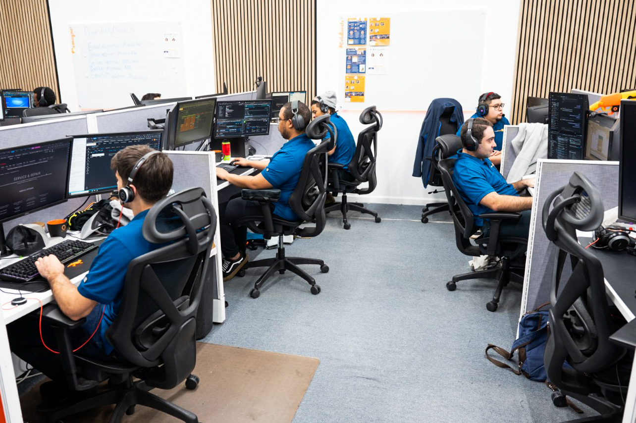 a group of men sitting at computers in an office