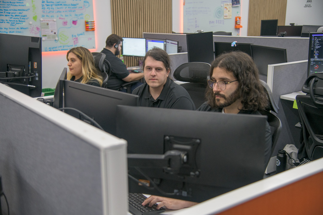 tech-focused team collaborating in modern office workspace with open-plan layout and creative atmosphere.