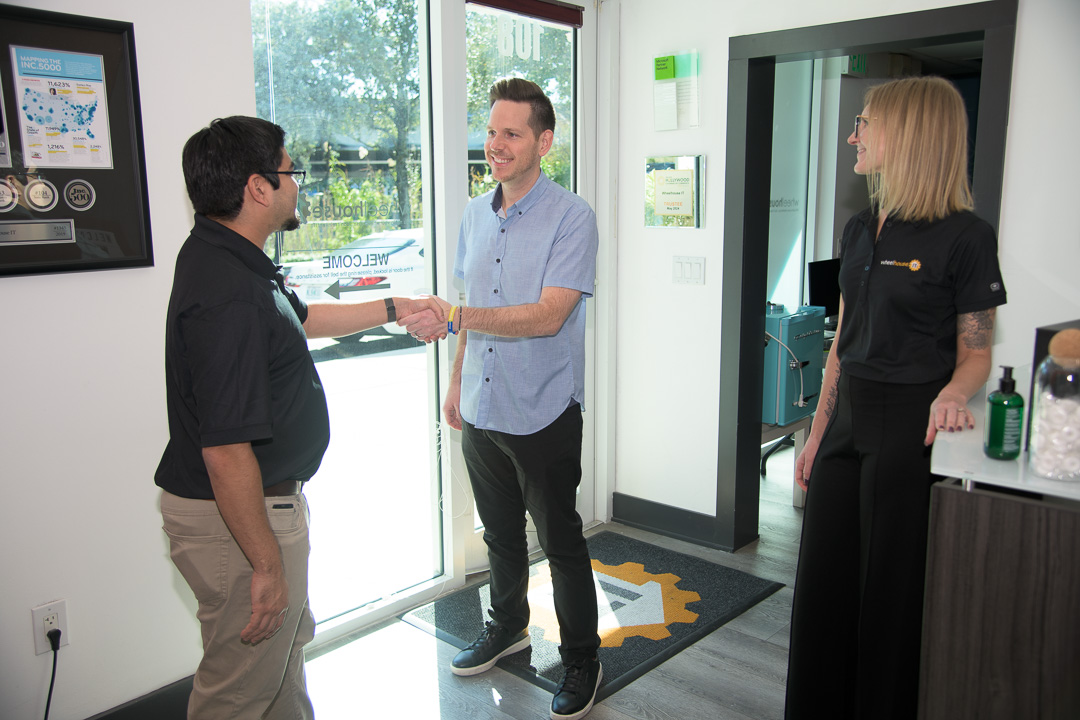 modern office with friendly professionals greeting each other in a bright, welcoming space.