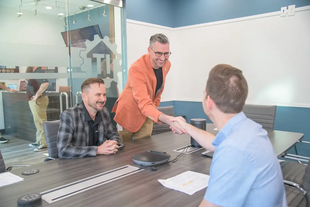 modern business meeting in sleek conference room with handshake, collaboration, and professional interaction.