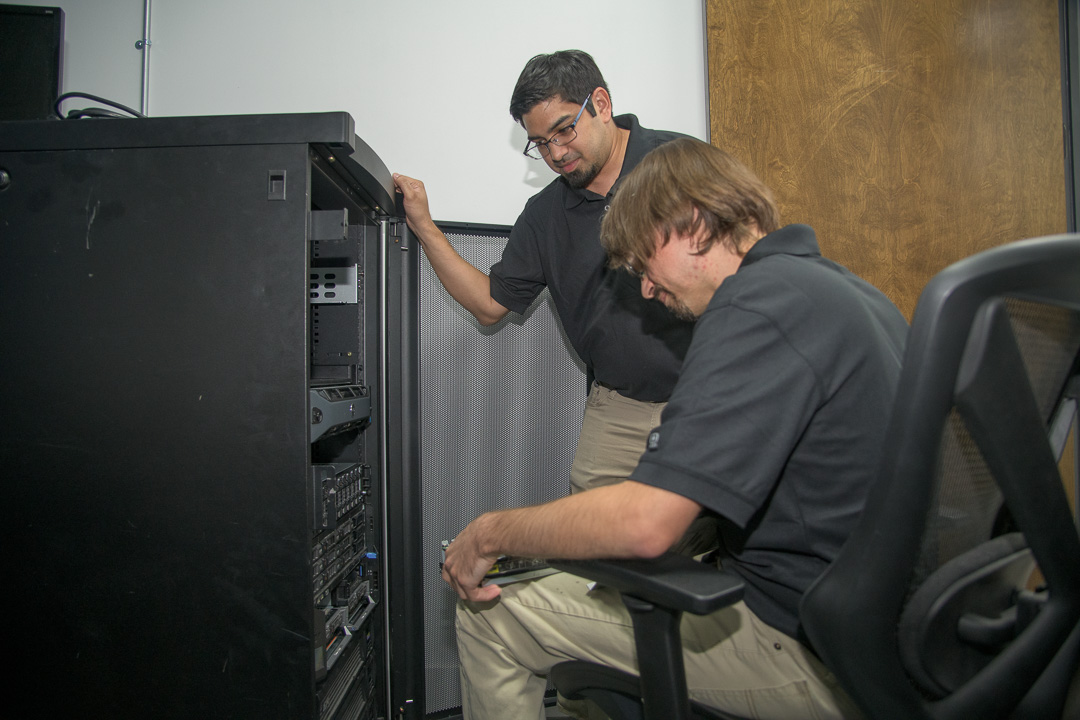 professional teamwork performing maintenance on a server rack in a modern workplace.
