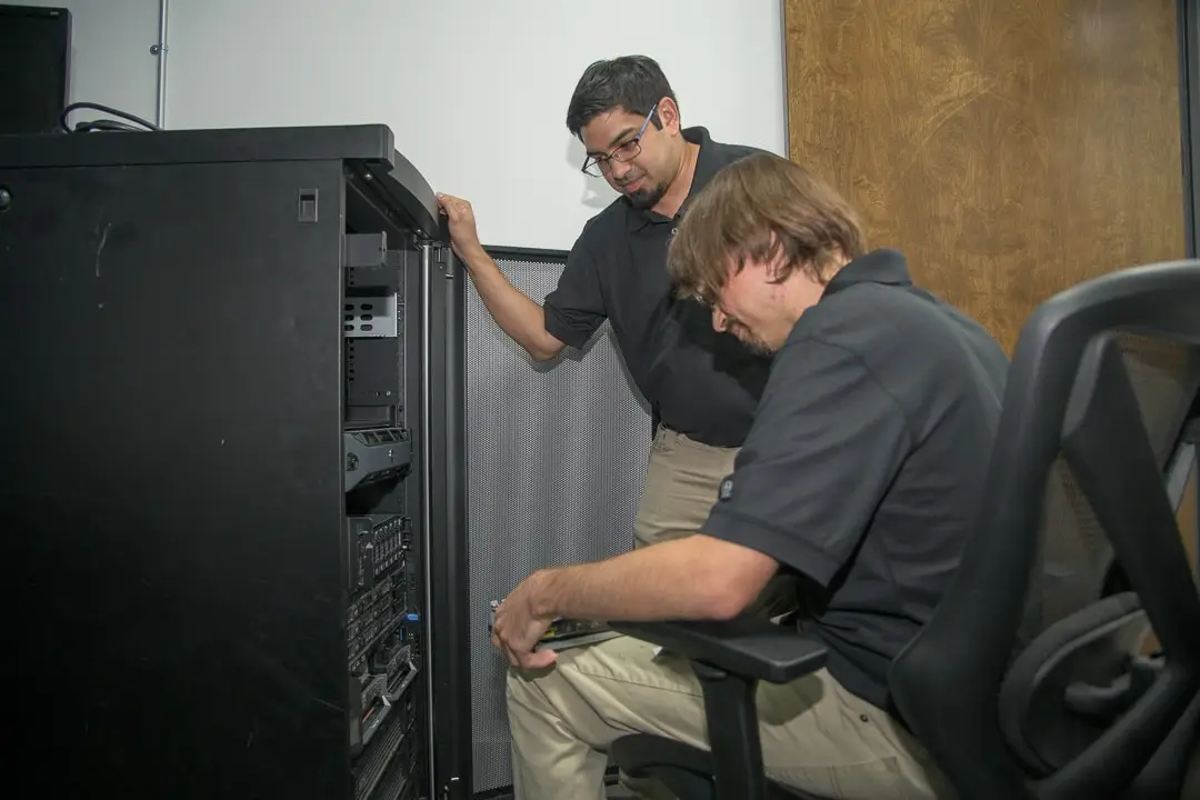 professional teamwork performing maintenance on a server rack in a modern workplace.