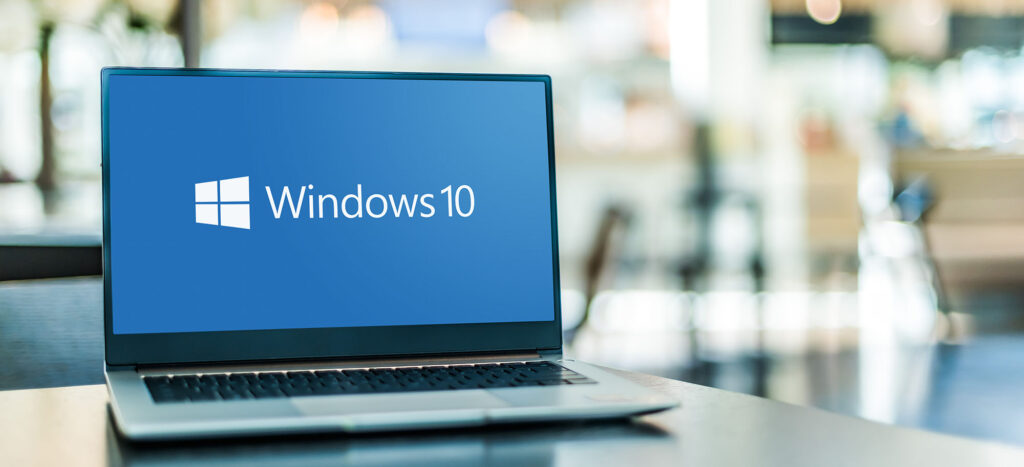 sleek laptop displaying windows 10 logo in urban setting, symbolizing modern technology.
