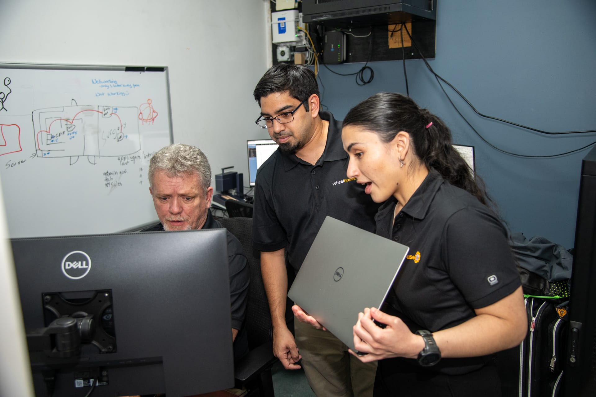 team collaborating in dynamic tech workspace with modern decor and computer monitors.
