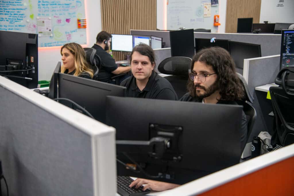 collaborative tech workspace with diverse team members focused on monitors.