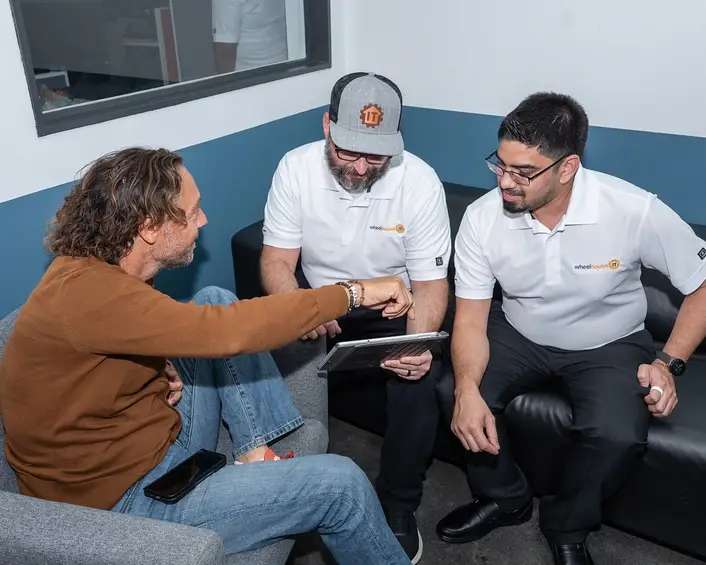 cloud managed services team members collaborate while reviewing a tablet in a casual office.