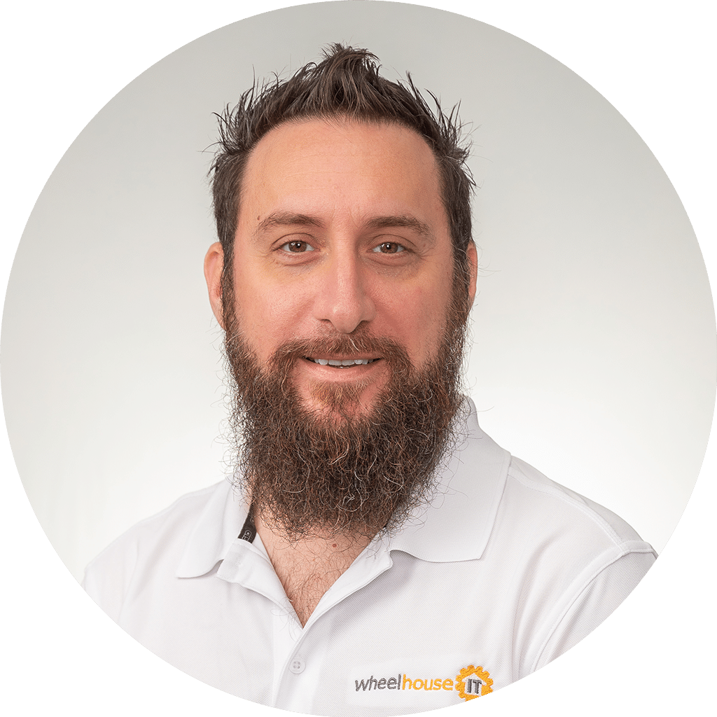 professional man in white polo shirt with wheelhouse it logo, displaying friendly demeanor.