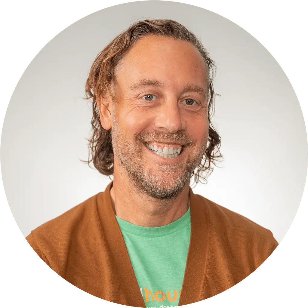 smiling man in cardigan radiating friendliness and approachability.