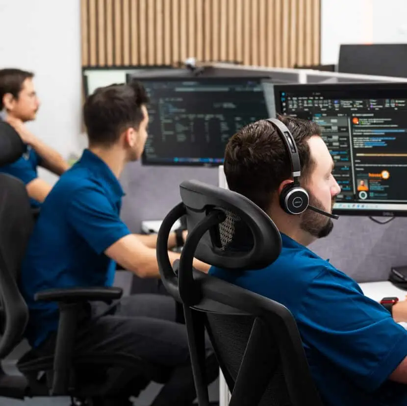 software team monitoring data on multiple screens in a modern operations center.