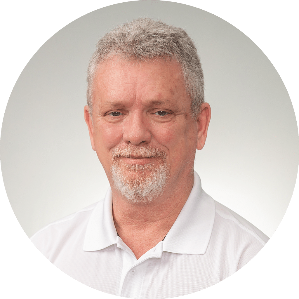 middle-aged man with gray hair and white polo shirt against a serene gray background.