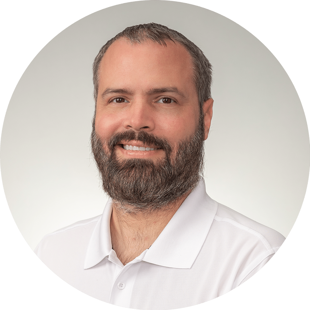 professional man in white polo shirt with well-groomed beard and warm smile.