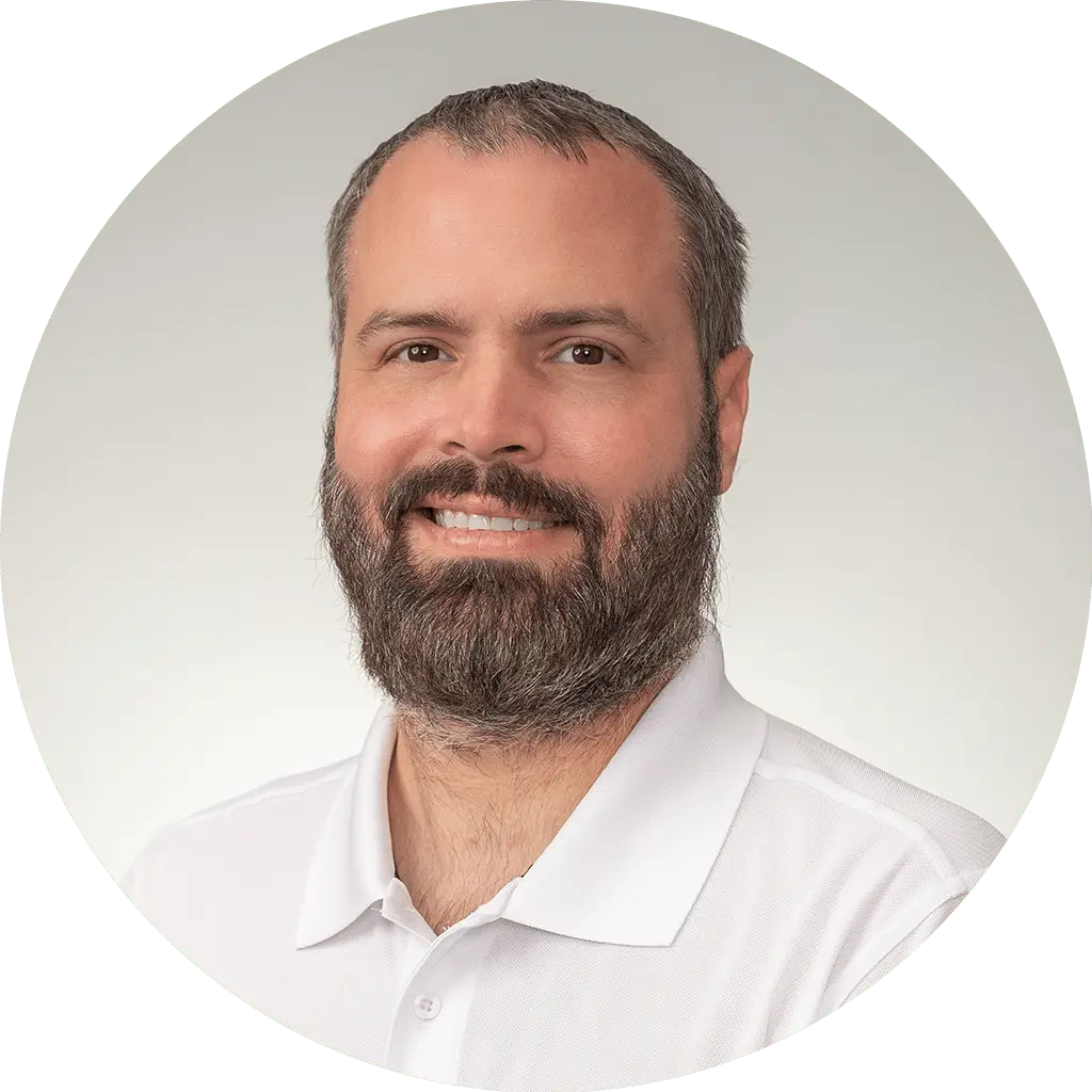 professional man in white polo shirt with well-groomed beard and warm smile.