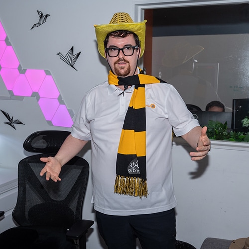 young man in vibrant sports attire exuding team spirit in modern office setting.