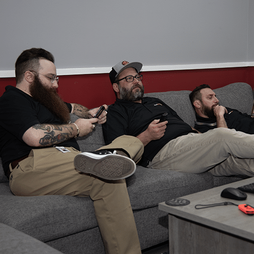 three friends lounging on a stylish couch in a cozy modern room.