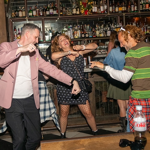 vibrant group enjoying lively night at bar with dancing, music, and joyful atmosphere.