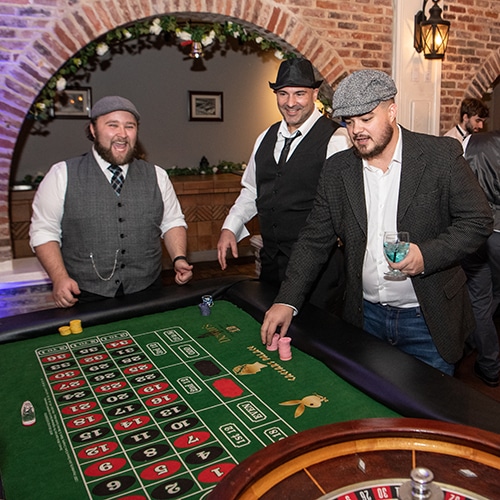 men playing roulette at a lively casino event with stylish attire and festive ambience.