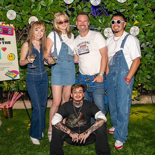 cheerful group of friends in stylish denim outfits at festive outdoor gathering.