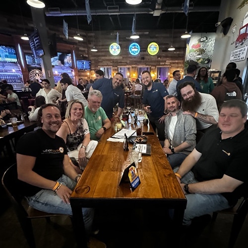 group of friends enjoying drinks and laughter in a vibrant, modern bar setting.