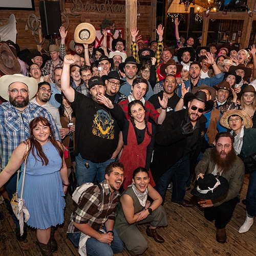 vibrant western themed party with diverse crowd in rustic setting.