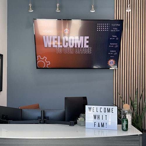 modern office reception desk with welcoming message and stylish decor for a professional setting.