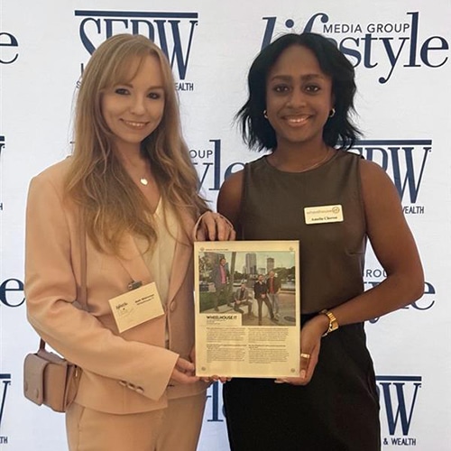 two professional women networking and celebrating success at a media event.