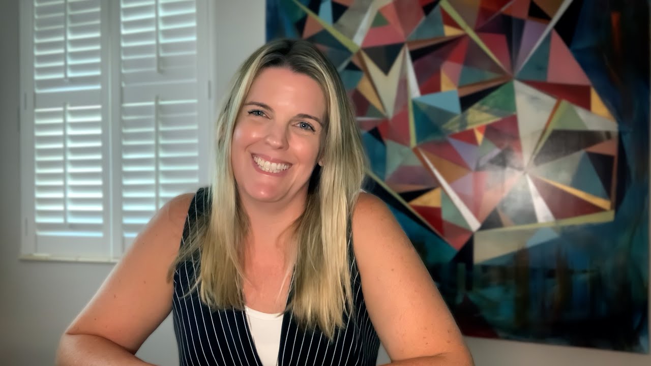 smiling woman in stylish office setting with colorful abstract art.