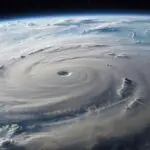Hurricane IT Preparedness Guide with a massive storm swirling over Earth from space
