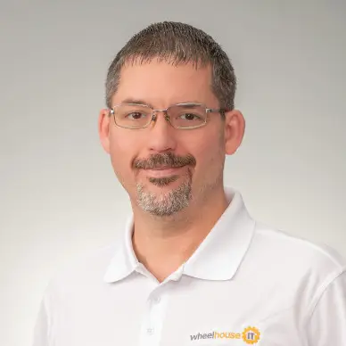 management team member wearing glasses and a white wheelhouse polo shirt.