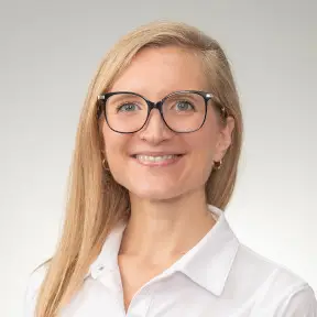smiling management team professional in a white shirt and glasses.