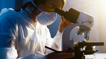 a woman looking through a microscope at something