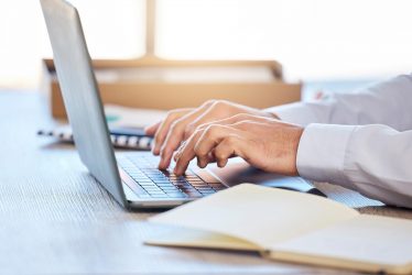 a person typing on a laptop at a desk