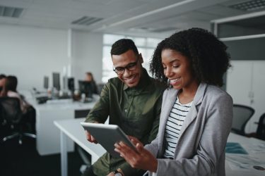 a man and woman are looking at a tablet