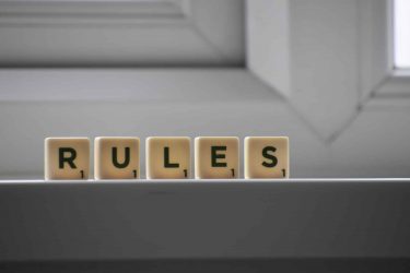 the word rules spelled with scrabble tiles